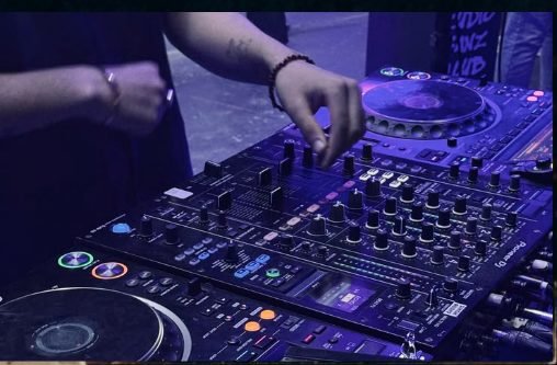 DJ tocando na cabine com controladora